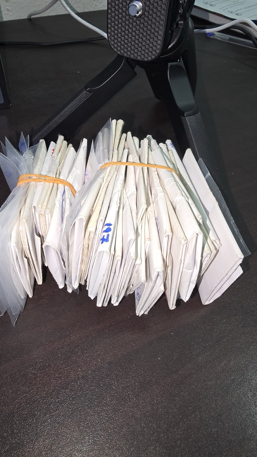 A bound stack of folded gemstone parcel papers on a dealer’s desk in Sri Lanka, the format in which rough and cut stones actually change hands